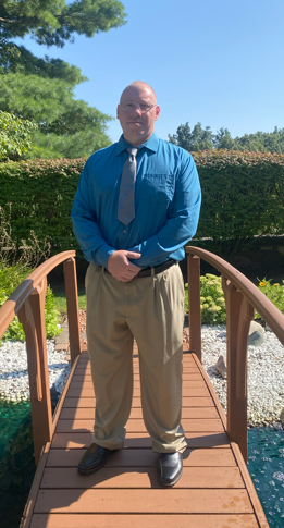 Carl LaLonde on a wooden bridge dressed for a formal event